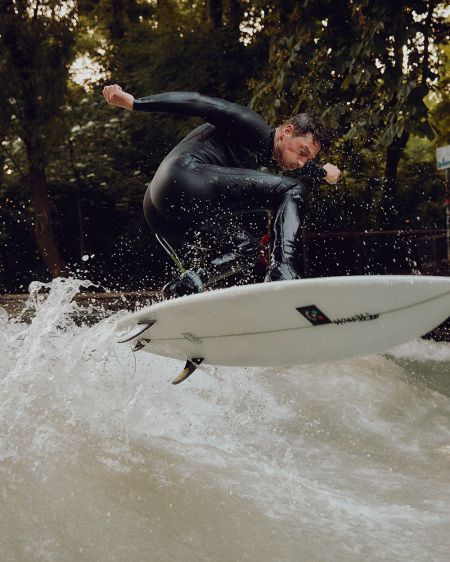 Sebastian Kuhn river-surfs at the Eisbach in Munich
