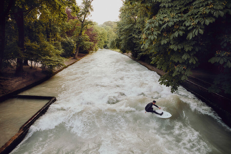 River surfing at the Eisbach in Munich The Munich Eisbach wave and a surfer
