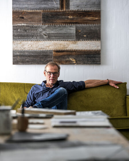 Hans Panschar sitting on a green couch in his living room