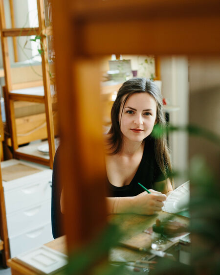Portrait of KPM employee Michelle Sosna, photographed through the frame of a chair