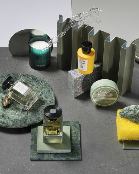 Still life with green and yellow beauty products on marble plates and surfaces in grey and blue