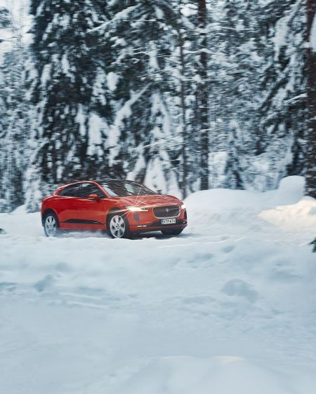 The Jaguar I-PACE in the middle of a snow-covered forest in finland
