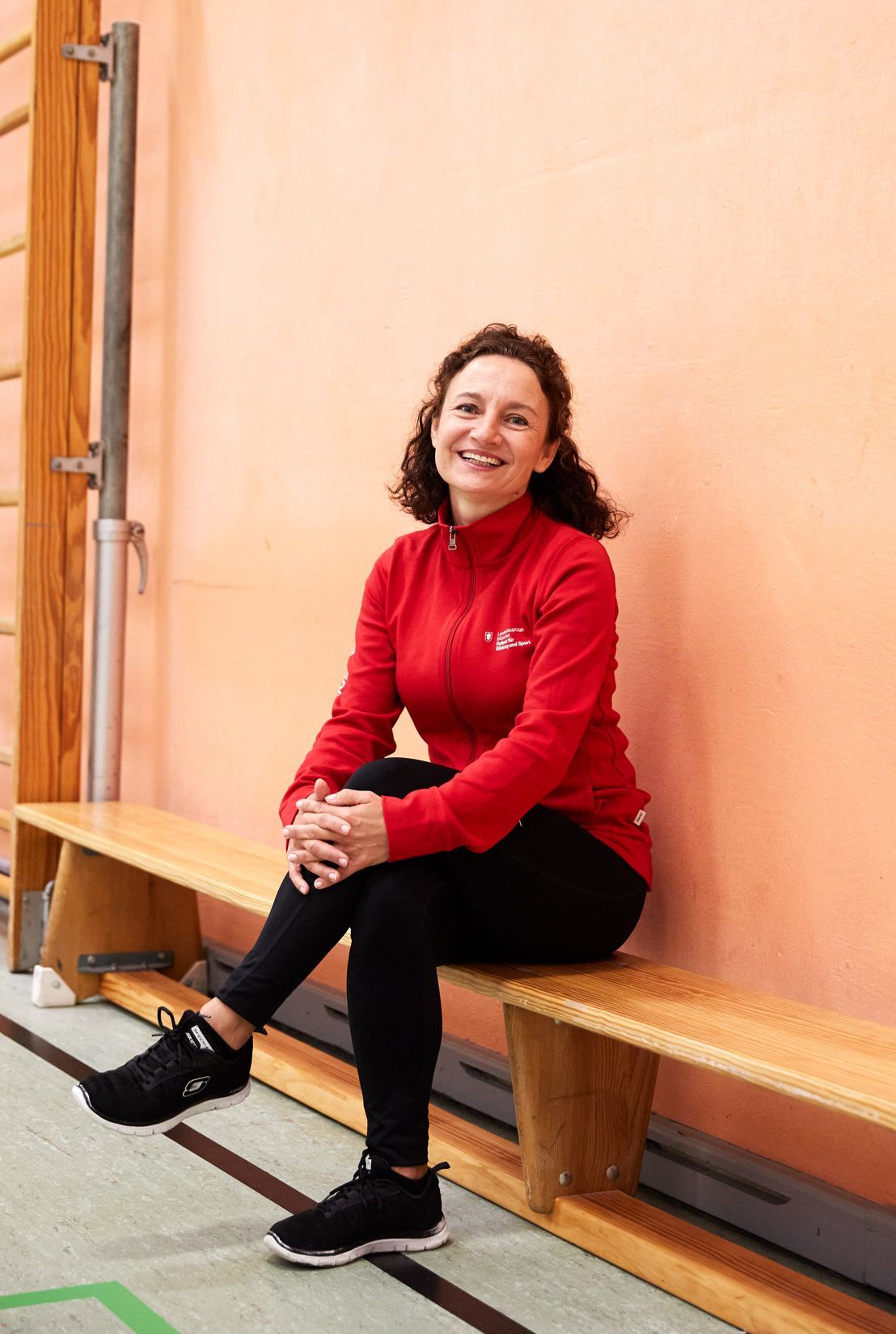 SWM: Passion Projects Fitness trainer sitting on bench in a gym