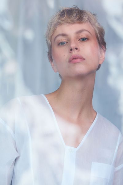 LUDWIG BECK Beauty: Covershooting für die Frühjahr-/Sommerausgabe 2020 Nahaufnahme einer jungen Frau mit kurzen Haaren vor weißem Hintergrund mit blauem Filter fotografiert