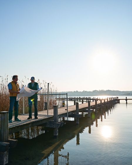 Anderl and Karl-Michael Friedinger standing on a jetty by the lake