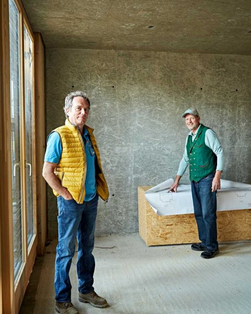 Anderl and Karl-Michael Friedinger in an interview for SeeMagazin Anderl Friedinger (left) and Karl-Michael Friedinger (right) stand in room with unplastered walls
