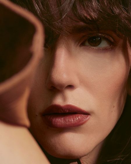 Young woman with brown curls and red lipstick