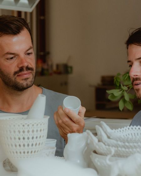 Two men look at porcelain tableware from the Royal Porcelain Manufactory KPM in Berlin