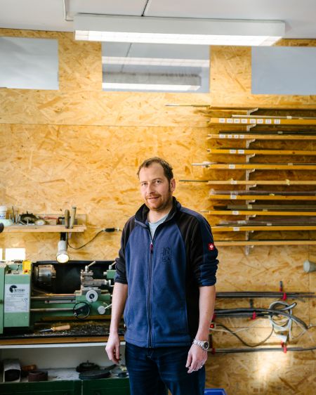 Instrument maker Hans Krinner is standing in his workshop