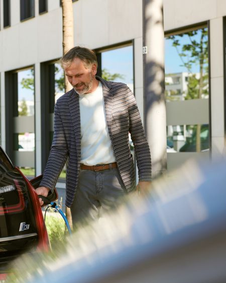 Man recharges his electric car at a charging station of Stadtwerke München