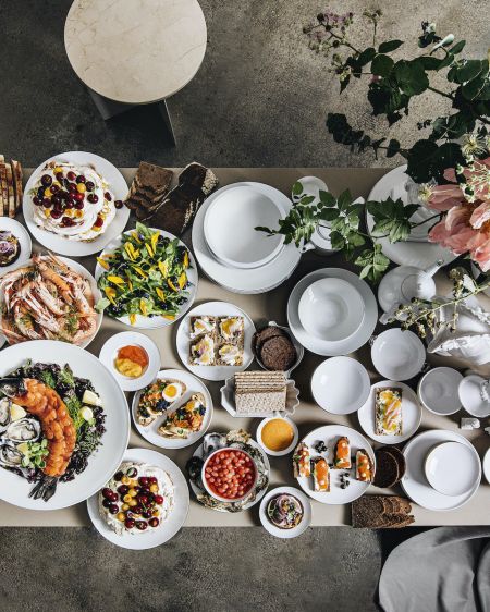 Richly laid table with lots of porcelain plates and Scandinavian food