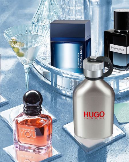 Gin tonic glass stands between different bottles with fragrances for men