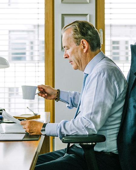Dr. Thomas Puffe sits on his office desk holding KPM porcelain cup