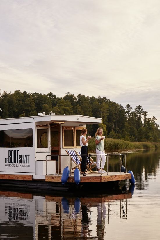Urlaub mit dem Hausboot auf der Havel Hausboot beim Sonnenuntergang zwei Frauen mit Tassen in der Hand