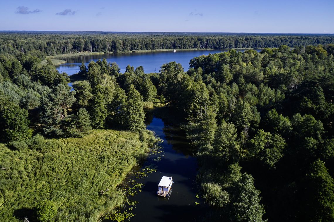 Urlaub mit dem Hausboot auf der Havel Boot von oben auf Fluss umgeben von Wald