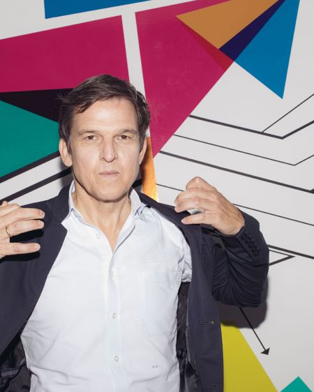 Christoph Schneider, Amazon Prime boss in front of wall with colored arrows