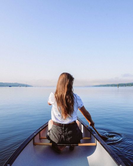 Young woman in canoe rowing