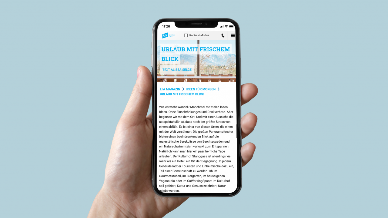 Hand holding smartphone displaying article page from LfA online magazine Hand holding smartphone displaying article page from LfA online magazine